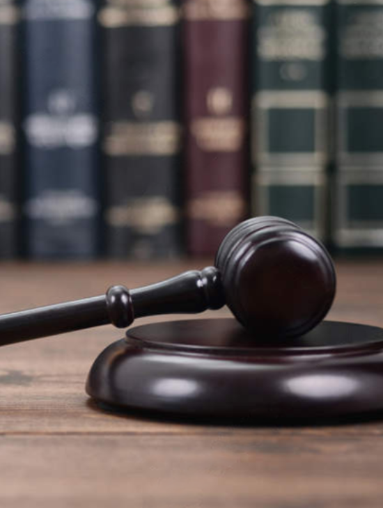 Mazo de juez en mesa con libros de derecho